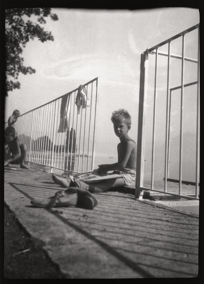 Des enfants en bonne santé jouent près du lac. Ils sont en chemisette et en pantalon court. Ce document a été vraisemblablement utilisé pour promouvoir les bienfaits du plein air et du soleil dans le cadre de la lutte contre la tuberculose.