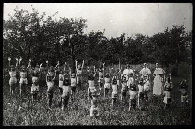 Dans le cadre de la lutte contre la tuberculose, des enfants font des exercices de gymnastique sur un champ.