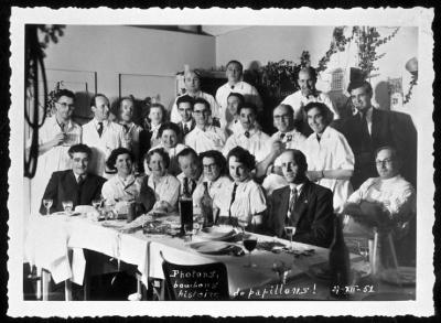 Groupe de médecins attablés, vraisemblablement à l'occasion des fêtes de Noël.