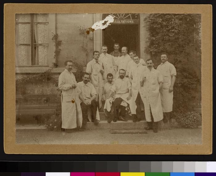 Groupe de médecins devant l'entrée du service des consultations situé dans les dépendances de l'Hôpital cantonal  (nord de la cour principale).