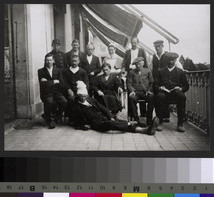 Un groupe de soigants et de patients pose sur la véranda de l'Hôpital cantonal.