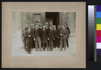 Portrait d'un groupe de notables prise devant l'Hôpital cantonal. Le Dr Paul Narbel est le premier au premier rang depuis la gauche, suivi du docteur Emile Dind (2e au premier rang depuis la gauche). Le docteur Nicolas Popoff se tient à côté de la colo…