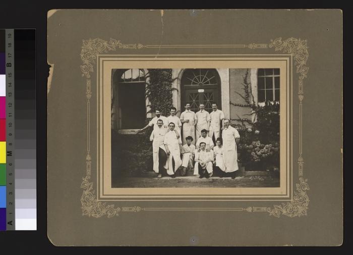 Groupe de médecins, dont deux femmes, devant une entrée de l'Hôpital cantonal.