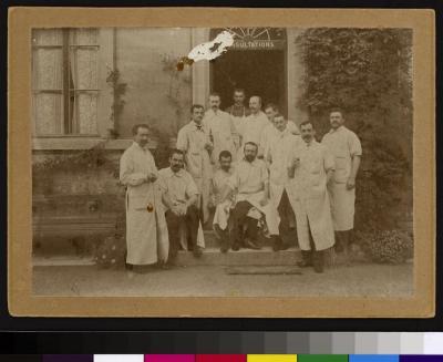 Groupe de médecins devant l'entrée du service des consultations situé dans les dépendances de l'Hôpital cantonal  (nord de la cour principale).