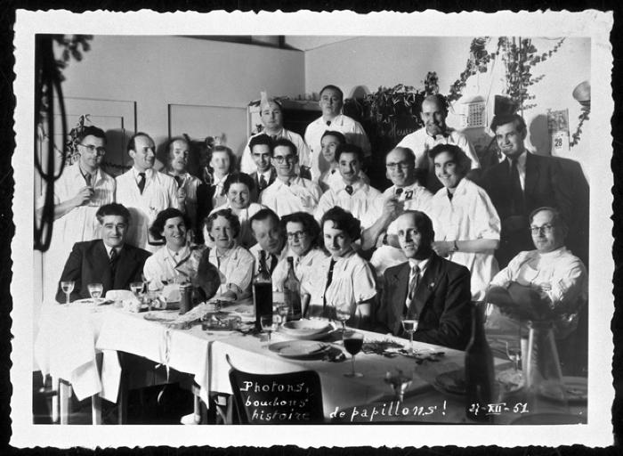 Groupe de médecins attablés, vraisemblablement à l'occasion des fêtes de Noël.