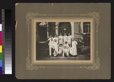 Groupe de médecins, dont deux femmes, devant une entrée de l'Hôpital cantonal.