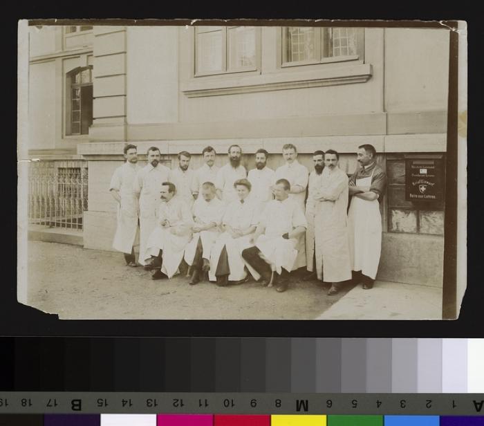 Groupe de médecins, dont une femme, devant vraisemblablementl'Hôpital cantonal.