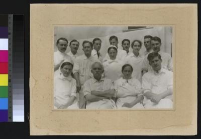 Portrait du Professeur César Roux (2e depuis la gauche, premier rang) entouré d'un groupe de médecins et d'infirmières.