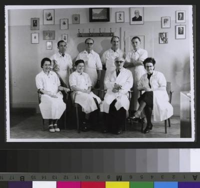 Portrait du Professeur Alfred Rosselet (2e depuis la droite, au premier rang) avec un groupe de médecins. A l'arrière, une paroi avec des portraits de médecins, dont celui du Dr César Roux et celui du Dr Henri Vuillet (en haut à gauche de l'image).