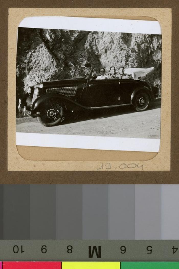 Hommes et femme dans un Mercedes décapotable.