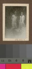Portrait de deux jeunes filles dans un jardin.