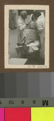 Le Dr. César Roux auscultant une patiente dans l'auditoire de médecine.