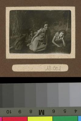 Portait de trois femmes assises sur l'herbe.