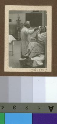 Le Dr. César Roux auscultant une patiente dans l'auditoire de médecine.