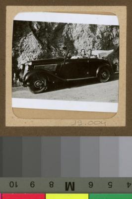 Hommes et femme dans un Mercedes décapotable.