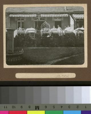 Enfants sur leurs lits sur la terrasse d'un hôpital.