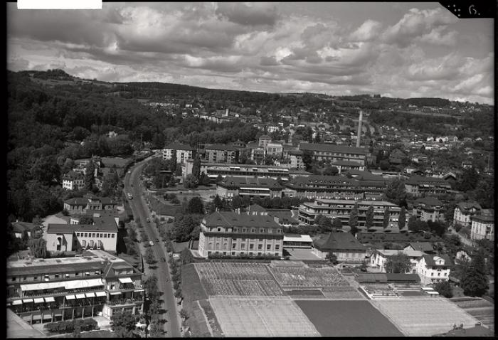 Vue du site de Champ de l'Air avant la construction du CHUV. Au centre, derrière les champs, l'actuel Institut de microbiologie. A gauche du bâtiment, la rue du Bugnon. Au bas, a gauche, une des ailes de l'hôpital cantonal. Au milieu, la clinique infan…