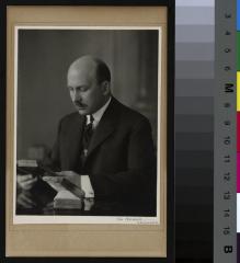 Portrait du Dr. William Boven , assis à une table, lisant un livre.
