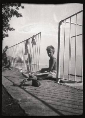 Des enfants en bonne santé jouent près du lac. Ils sont en chemisette et en pantalon court. Ce document a été vraisemblablement utilisé pour promouvoir les bienfaits du plein air et du soleil dans le cadre de la lutte contre la tuberculose.