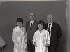 Groupe composé de deux hommes et deux femmes habillées en uniforme de travail.