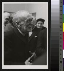Portrait du Prof. Bruno Galli-Valerio âgé, entouré d'un groupe d'hommes. A l'arrière-plan, à droite, Mme D. Picod-Roux, fille du Prof. César Roux.