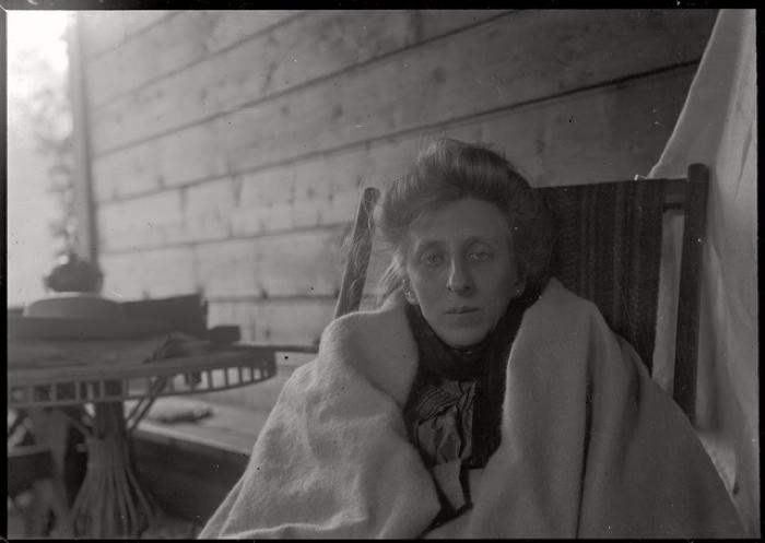 Portrait assis de la doctoresse Charlotte Olivier- von Mayer (1864-1945). Elle porte une sorte de couverture sur ses épaules.