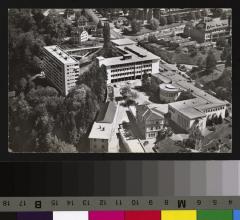 Vue aérienne du quartier des Hôpitaux et de la rue du Bugnon. Au premier plan à droite se trouve l'Institut de Pathologie (1942) avec le grand auditoire et la chapelle ainsi que le Centre anticancéreux romand. Au centre, la construction du Bâtiment des…