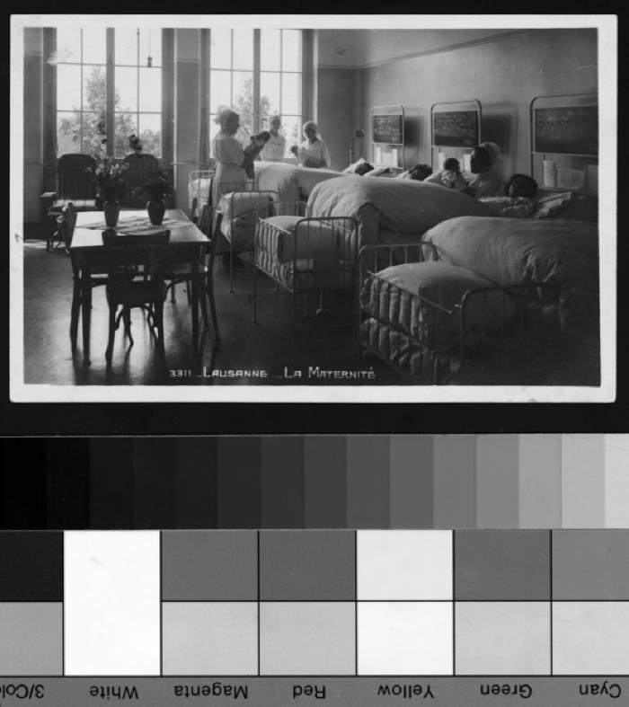 Salle commune à la maternité de Lausanne, mères et bébés dans leurs lits et infirmières.