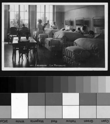 Salle commune à la maternité de Lausanne, mères et bébés dans leurs lits et infirmières.