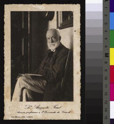 Portrait du docteur Auguste Forel (1848-1931) assis sur une chaise. Il est déjà âgé comme le montre son visage ridé, sa barbe et ses cheveux blancs. Il est assis sur une chaise avec un livre sur les genoux. Il porte un pantalon clair, un gilet et un ve…